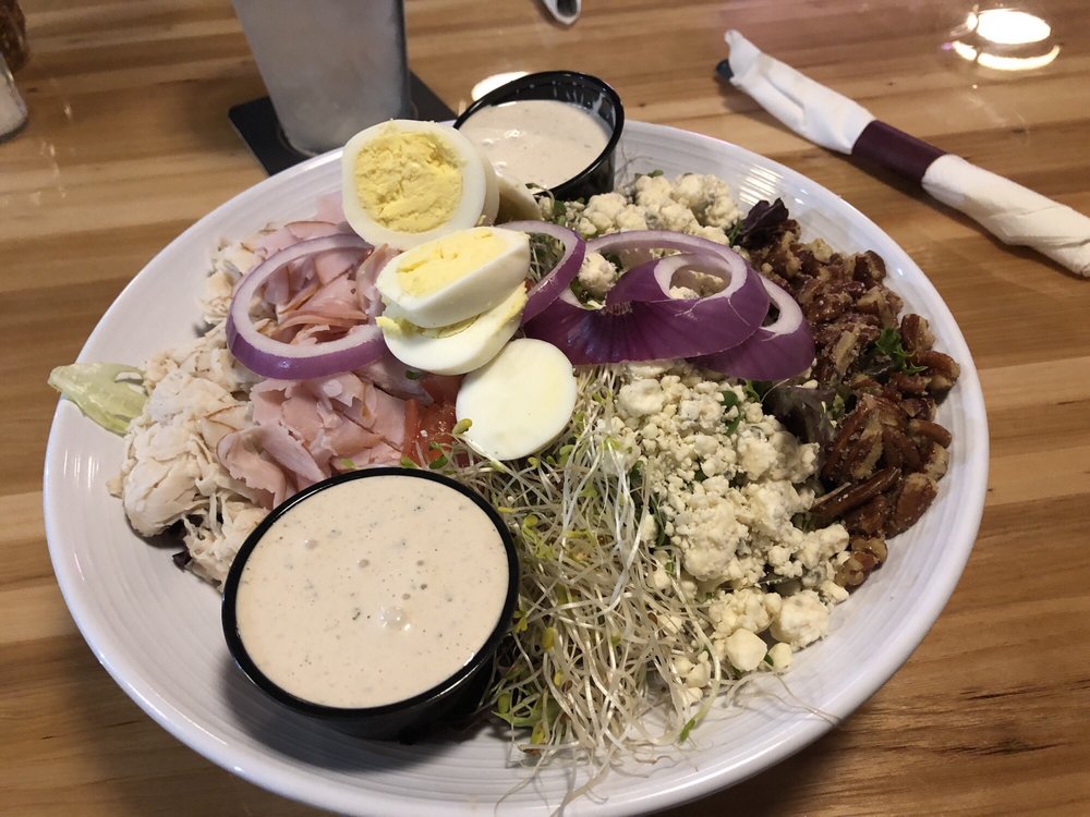 A Casablanca entrée salad with turkey, ham, egg, blue cheese, pecans, red onion, sprouts, and dressing